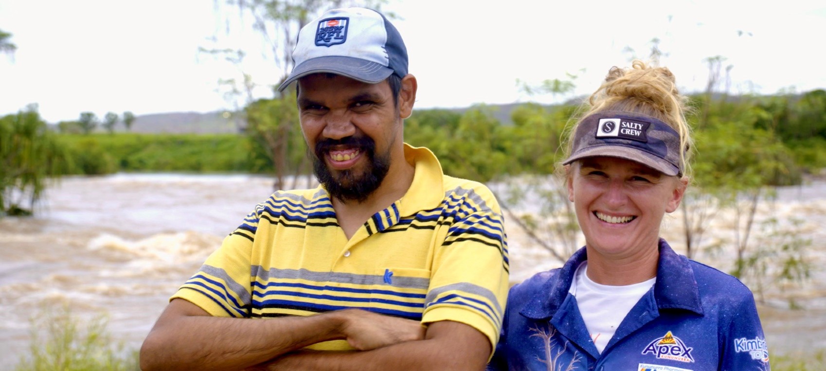 Two people standing with Ivanhoe Crossing in background